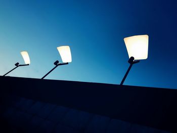 Low angle view of illuminated street light against clear sky