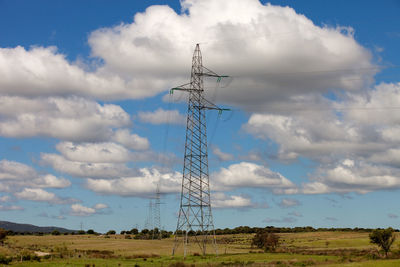 Low angle view of electricity pylon on field against sky