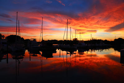 Silhouette of boats in lake during sunset