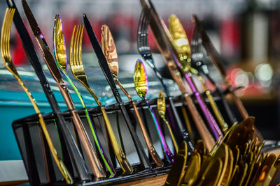 Close-up of multi colored knifes, forks and spoons in row