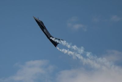 Low angle view of airplane flying against sky