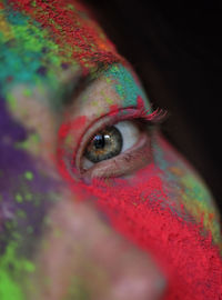 Close-up portrait of woman with multi colored powder paint