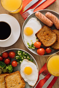 Flat lay english breakfast with cup of black coffee and orange juice, grilled sausage
