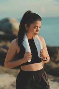 Side view of young woman standing at beach