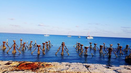 People on beach by sea against sky