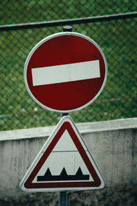 Road sign against fence