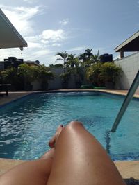 Low section of woman relaxing in swimming pool