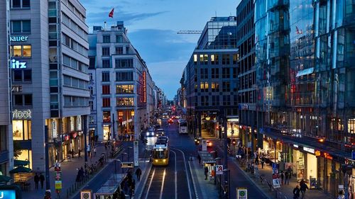 Vehicles on road in city against sky