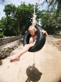 Cute girl sitting on tire swing