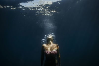 Rear view of shirtless woman in sea