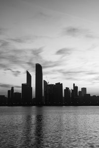 Sea by buildings against sky in city