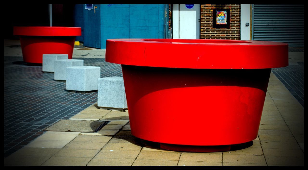 RED GARBAGE BIN ON FLOOR