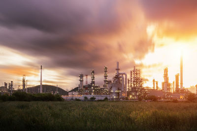 Panoramic view of factory against sky during sunset