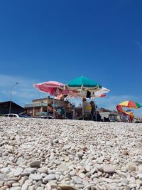 People on beach against clear blue sky