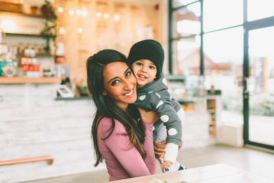 Portrait of smiling mother and daughter at cafe