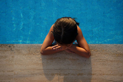 High angle view of girl relaxing in swimming pool