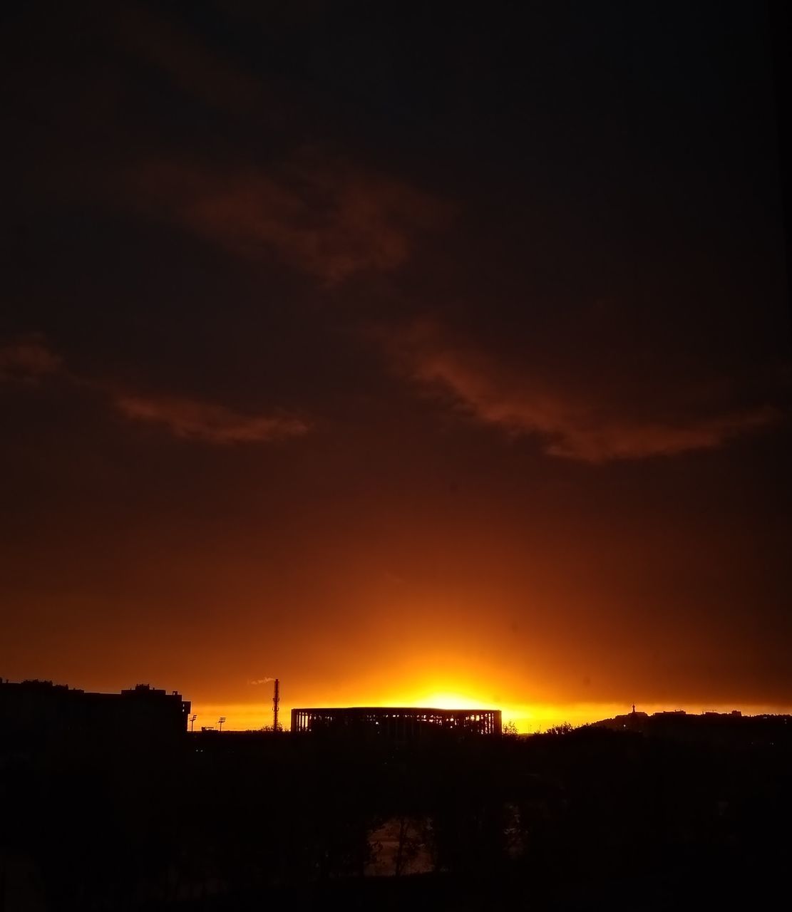 SILHOUETTE BUILDINGS AGAINST ORANGE SKY