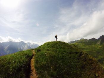 Man walking on mountain against sky