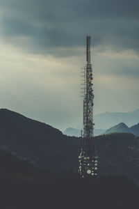 Communications tower against cloudy sky