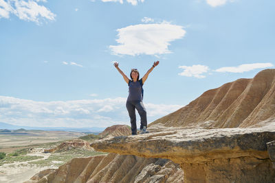 Full length of man standing on rock against sky