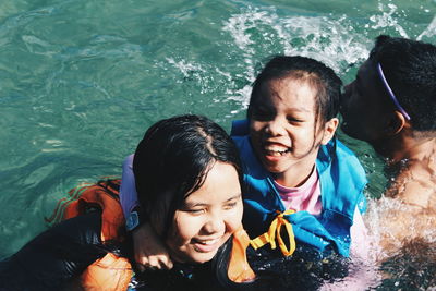 High angle view portrait of happy friends in swimming pool