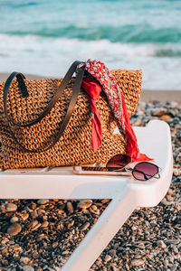 Close-up of shoes by stones on beach