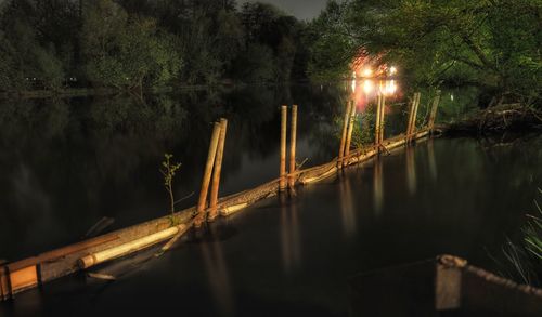 Illuminated bridge over lake at night