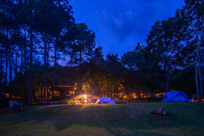 Illuminated tent on field against sky at night