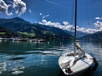 Sailboats moored in lake against sky