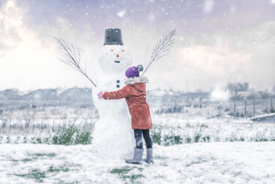 Rear view of woman standing on snow