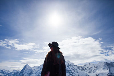 Woman standing against snow covered mountains and sky