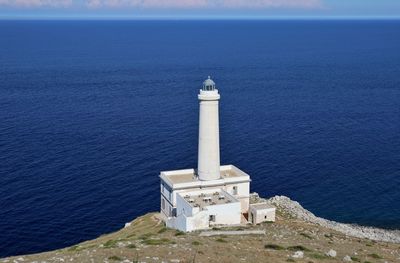 Lighthouse by sea against sky