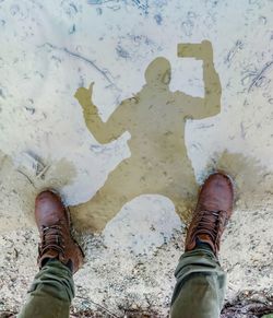 Low section of man standing by water