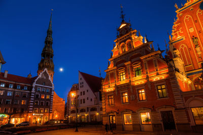 Low angle view of illuminated clock tower at night