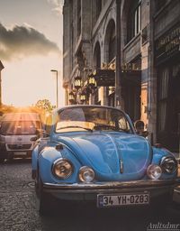 Vintage car on street against buildings in city