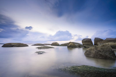 Rocks in sea against sky