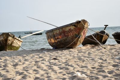 Abandoned boat on beach against clear sky