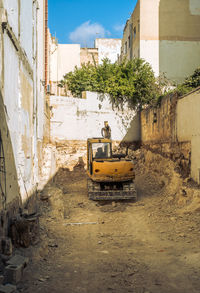 A yellow excavator digs the foundation of a building