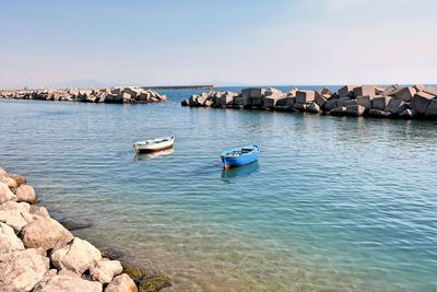 Boats in sea against clear sky