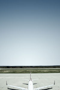 Airplane on runway against clear sky