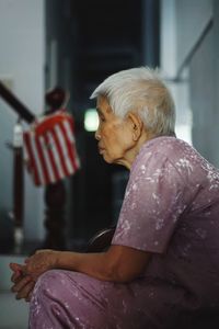 Side view of senior woman sitting at home