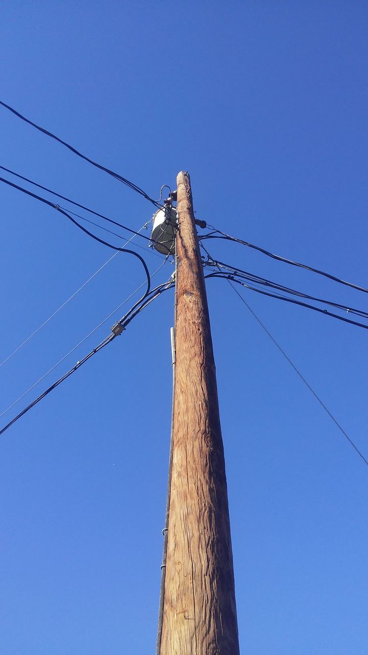low angle view, electricity, power supply, power line, blue, connection, no people, clear sky, sky, electricity pylon, technology, cable, tree, day, nature, outdoors