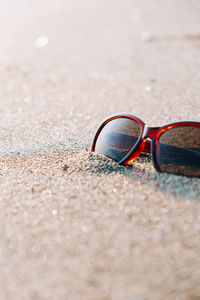 Close-up of sunglasses on sand