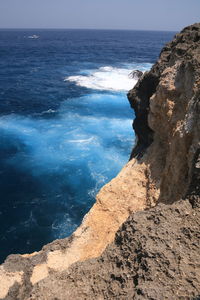 Deep blue sea and waves crushing on the rocks 