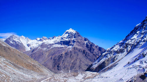 Scenic view of snowcapped mountains against clear blue sky