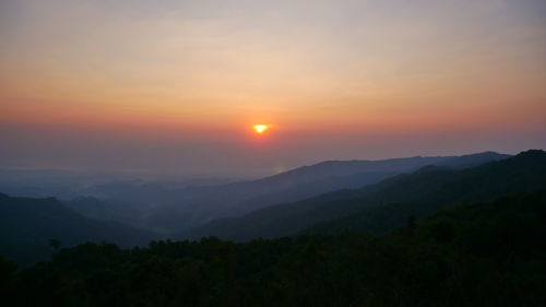 Scenic view of silhouette mountains against sky at sunset