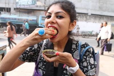 Portrait of woman eating water ball