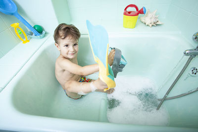 Boy playing with toy in bathroom