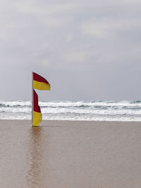 Lifeguard hut on beach against sky