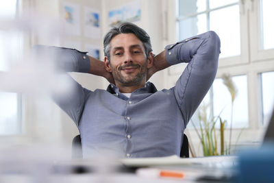 Portrait of smiling man at desk in office